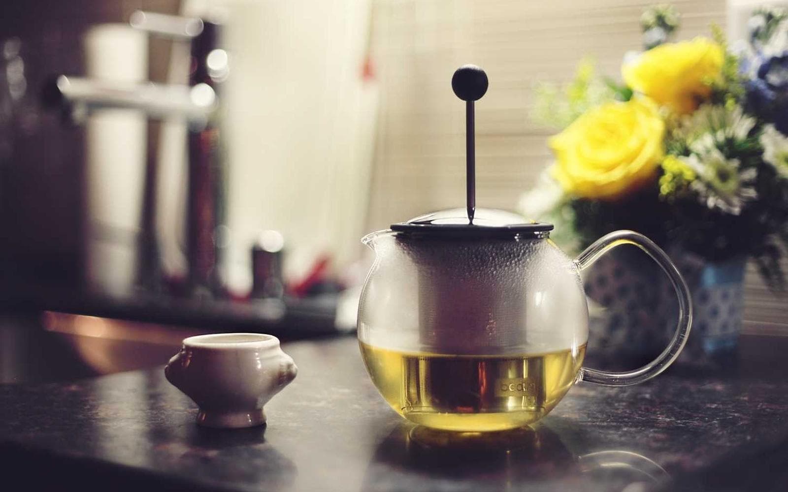 A teapot and flowers on a café table