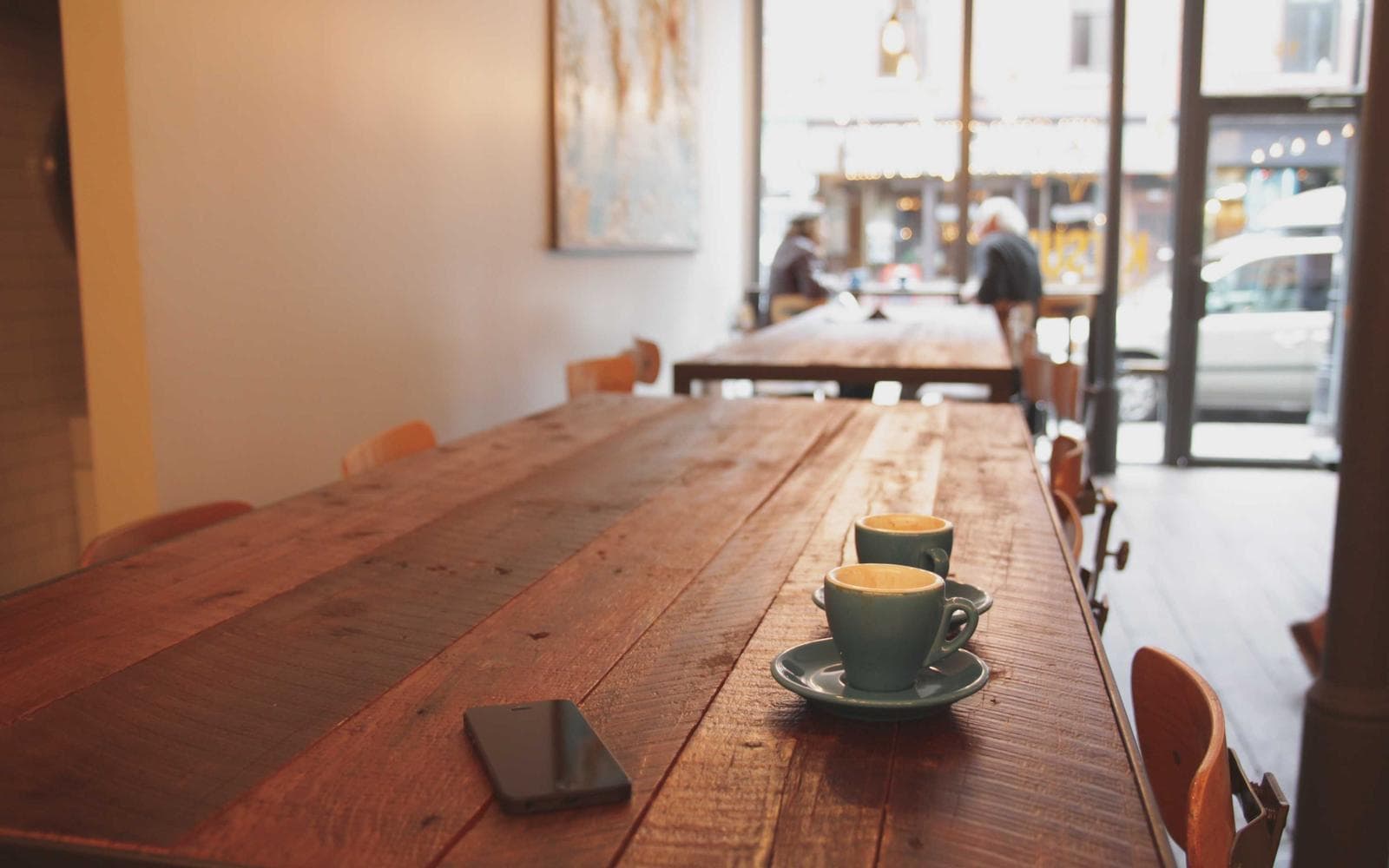 A long restaurant table in a warm, empty dining room